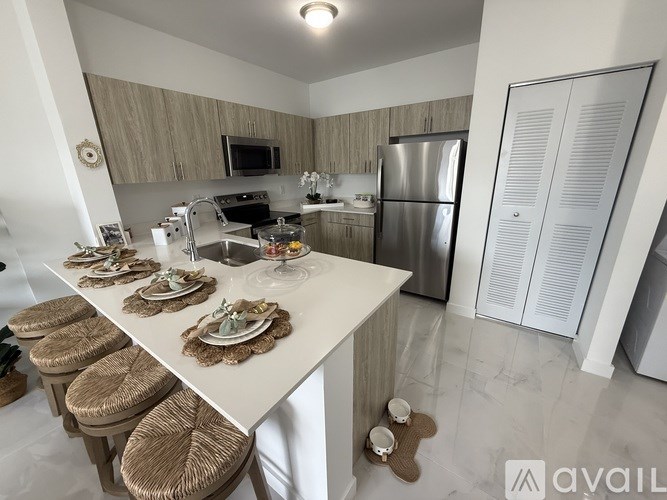 A kitchen with a white countertop and stools.
