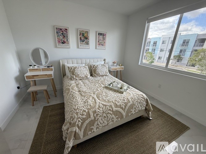 A bedroom with a large bed and a window overlooking a street.