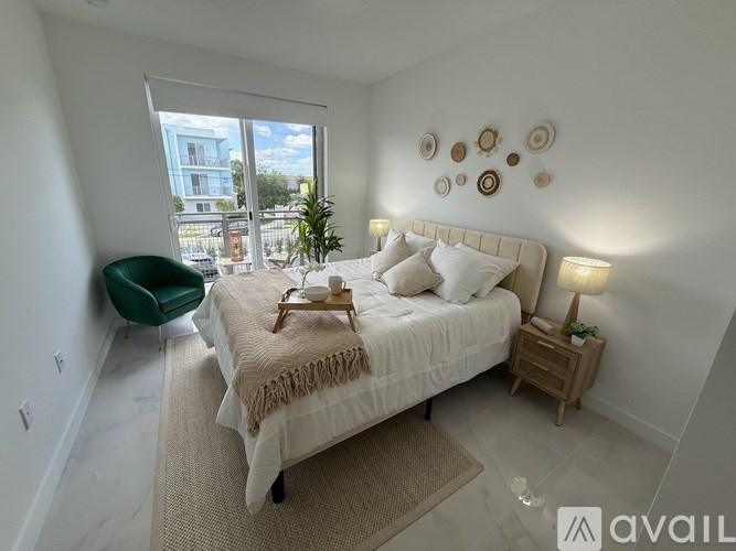 A bedroom with a large bed and a green chair.