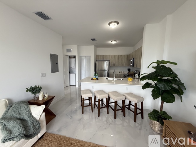 A kitchen with white cabinets and a white fridge is shown.