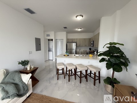 A kitchen with white cabinets and a white fridge is shown.