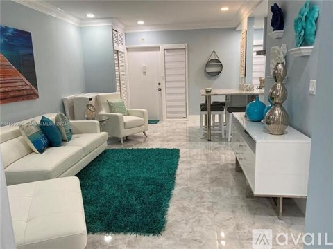 A living room with a white couch and a green rug.