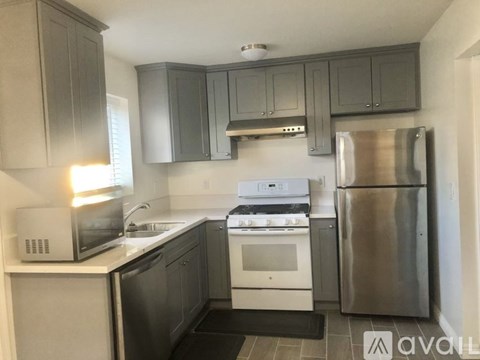 A kitchen with a stainless steel refrigerator, microwave, and oven.