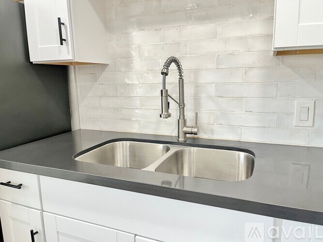 A modern kitchen with a stainless steel sink and faucet.