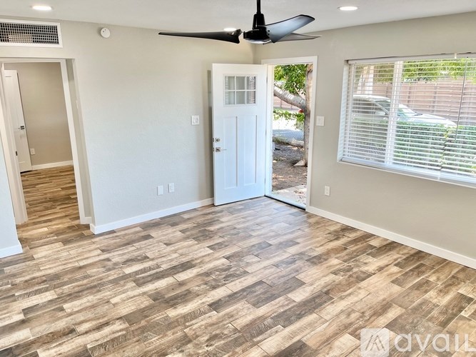 A room with a ceiling fan and a door leading outside.