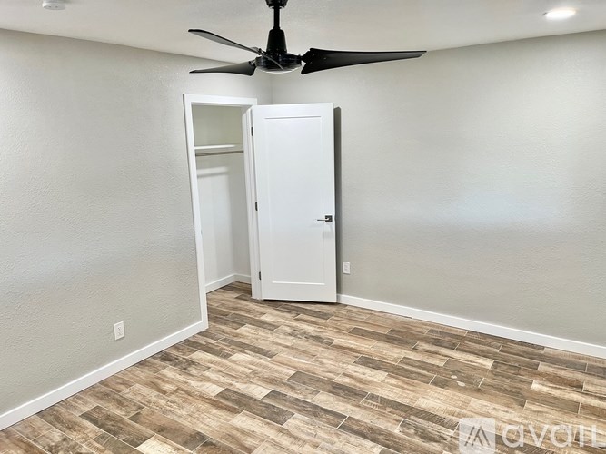 A room with a ceiling fan and a door.