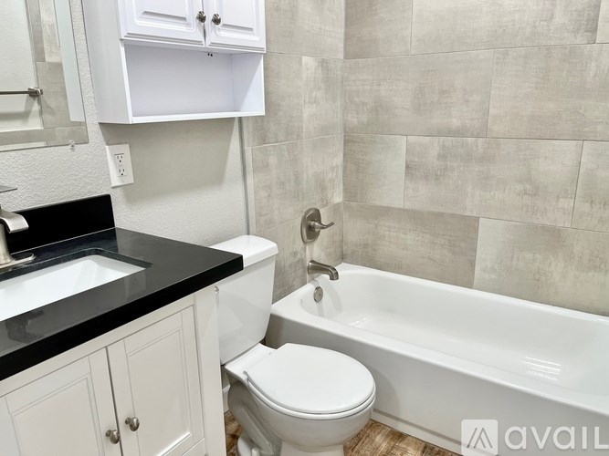 A bathroom with a white toilet, sink, and bathtub.