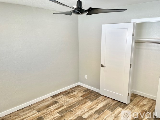 A room with a ceiling fan and a door.
