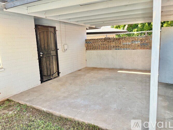 A white building with a black door and a white wall.