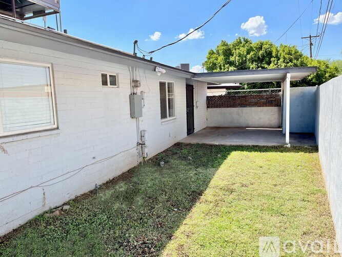 A small white house with a green lawn in front.