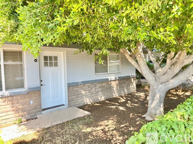 A tree is in front of a house.
