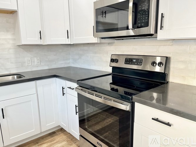 A modern kitchen with white cabinets and stainless steel appliances.