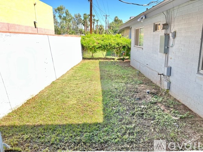 A white house with a green lawn in front.