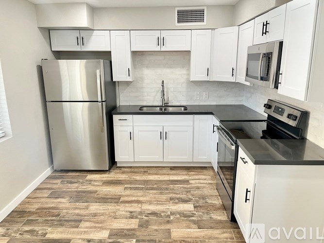 A kitchen with white cabinets and a tiled floor.