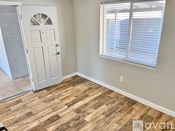 A room with a white door and a window with blinds.