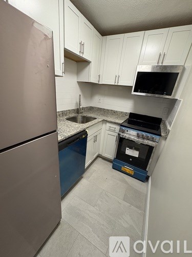A kitchen with a refrigerator, oven, and microwave.