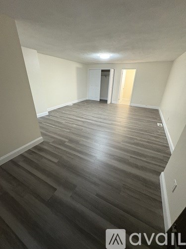 A hallway with wooden floors and white walls.