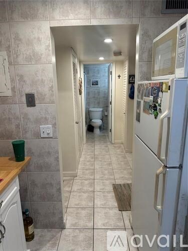 A kitchen with a white fridge and a wooden counter top.