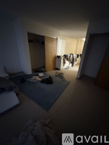 A room with a blue mat and clothes hanging on a line.