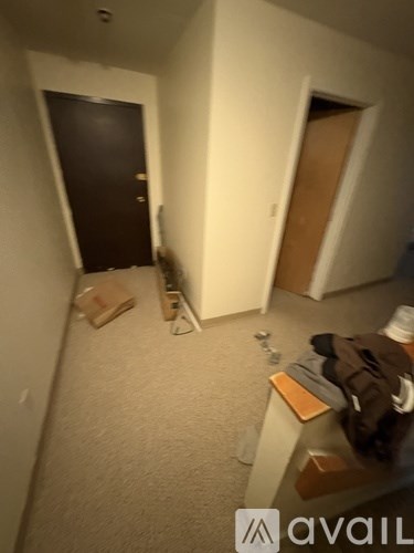 A hallway with a coat on a bench and a door on the left.