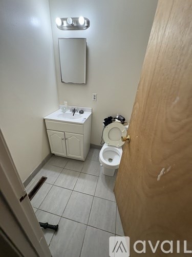 A bathroom with a toilet, sink, and mirror.
