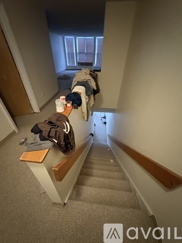 A staircase with a coat hanging on the railing.