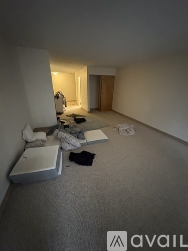 A room with a white chair and a white box on the floor.
