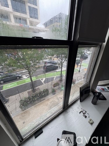 A view from a window looking out at a street with cars and buildings.