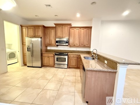 A kitchen with wooden cabinets and a tile floor.