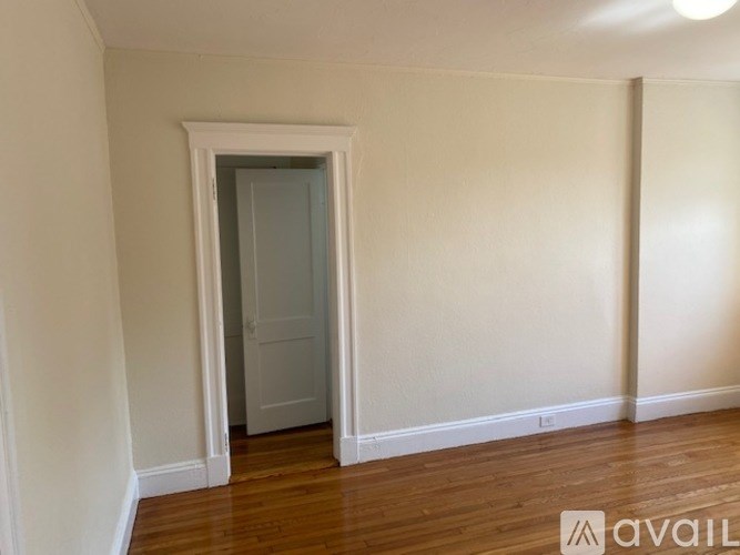 A room with a wooden floor and a white door.