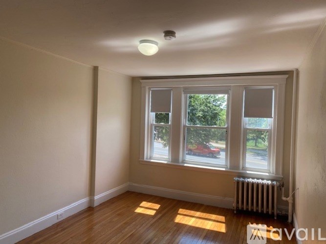 A room with a window and a radiator on the floor.