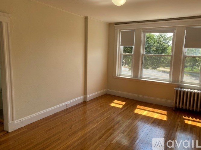 A room with wooden floors and a window showing daylight.