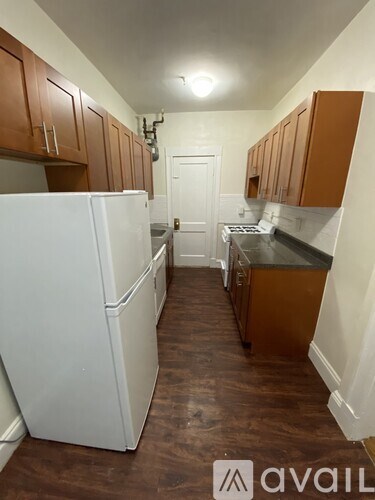 A kitchen with white appliances and wooden cabinets.