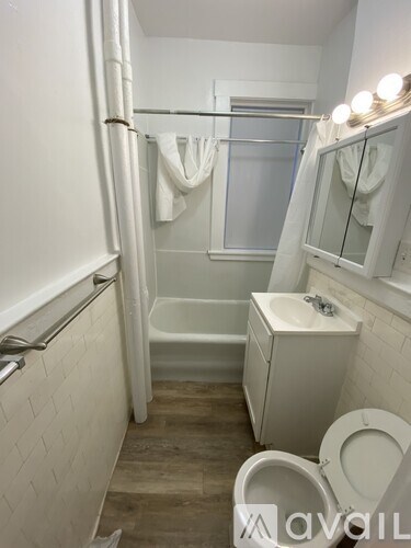 A white bathroom with a toilet, sink, and shower.