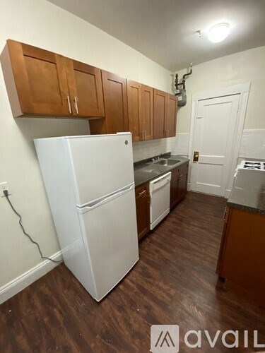 A kitchen with wooden cabinets and a white fridge.