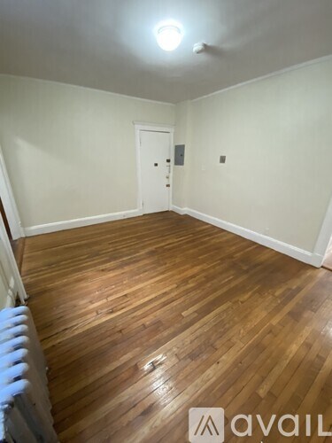 A room with wooden flooring and a white door.