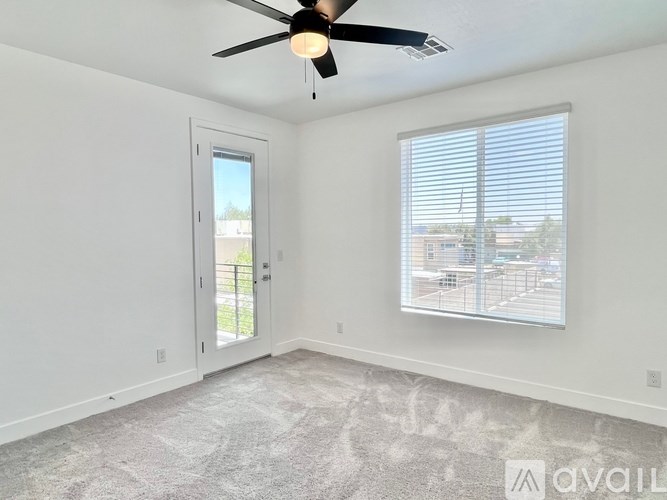 A room with a ceiling fan and a window with blinds.