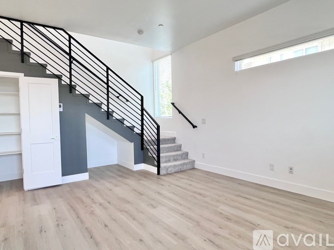 A spacious room with a staircase leading to the upper level.