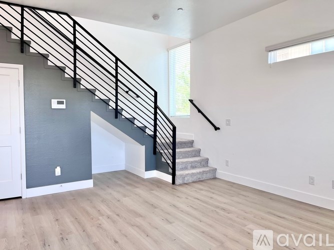 A spacious room with a staircase leading to the upper level.