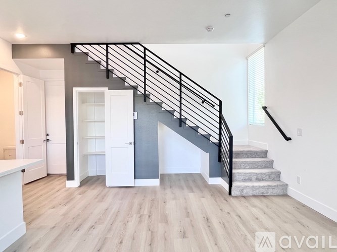 A spacious living room with a staircase leading to the upper floor.