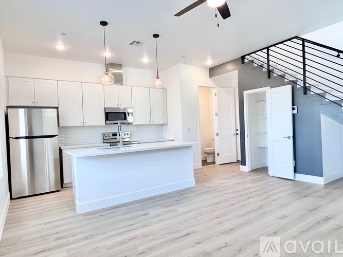 A modern kitchen with a refrigerator, microwave, and oven.