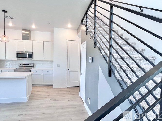 A modern kitchen with a staircase leading to the upper floor.