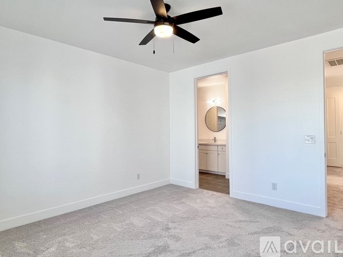 A room with a ceiling fan and a carpeted floor.