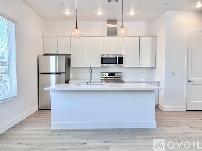 A modern kitchen with white cabinets and a central island.