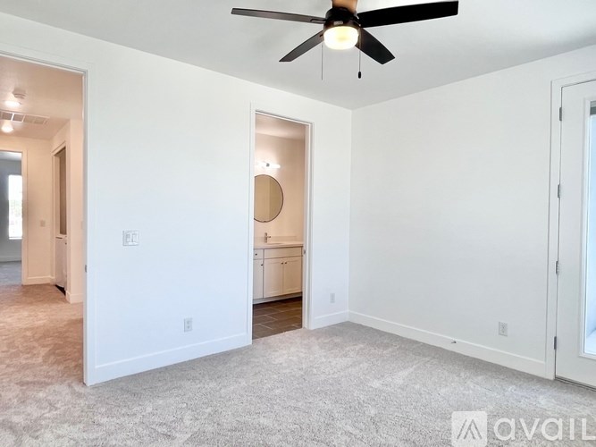 A room with a ceiling fan and a carpeted floor.