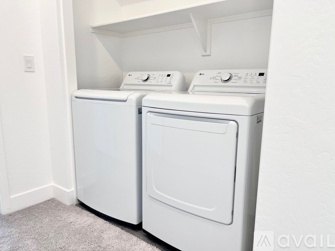 Two white front loading washing machines in a laundry room.