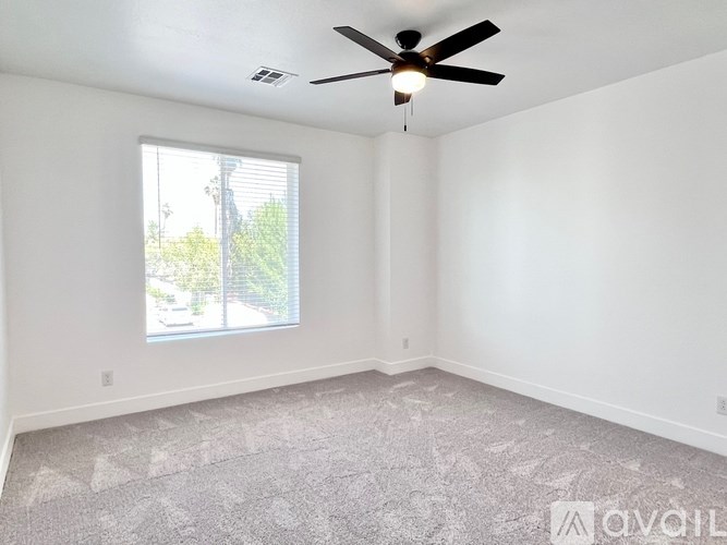 A room with a ceiling fan and a window.
