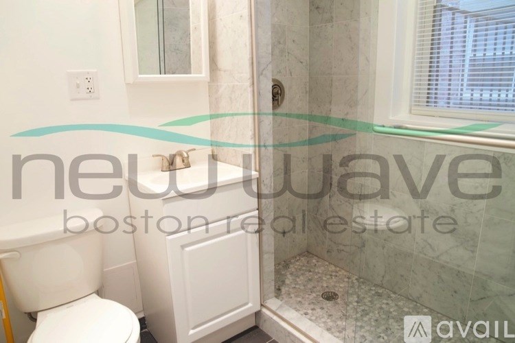 A bathroom with a toilet, sink, and shower.