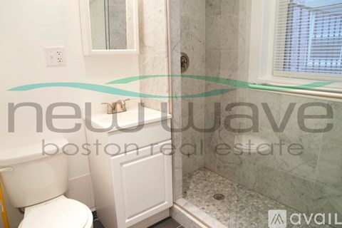 A bathroom with a toilet, sink, and shower.