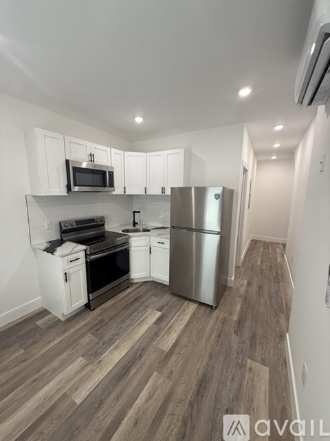 A kitchen with wood flooring and stainless steel appliances.